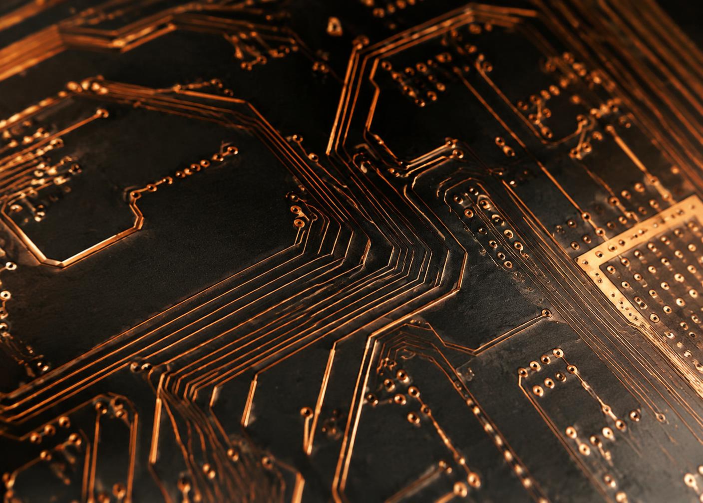 Macro view of copper traces on a dark circuit board